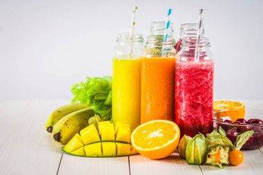 Mango, portakal, muz, cele şişelerde çok renkli smoothies