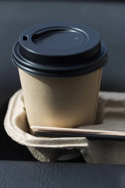 Coffee take-away in a paper cup in the car. — Stock Photo, Image