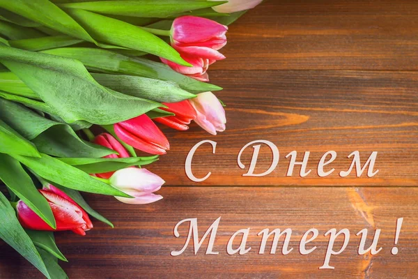 Różowe tulipany na drewniany stół z napisem w języku rosyjskim - Happy Mother's Day — Zdjęcie stockowe