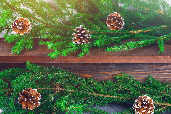 红新年的球果躺在一个木褐色的架子上, 四周是冷杉树枝. — 图库照片