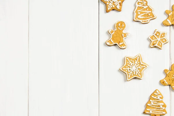 Christmas gingerbread cookies of different shapes on a white wooden table. Copy space. — Stock Photo, Image