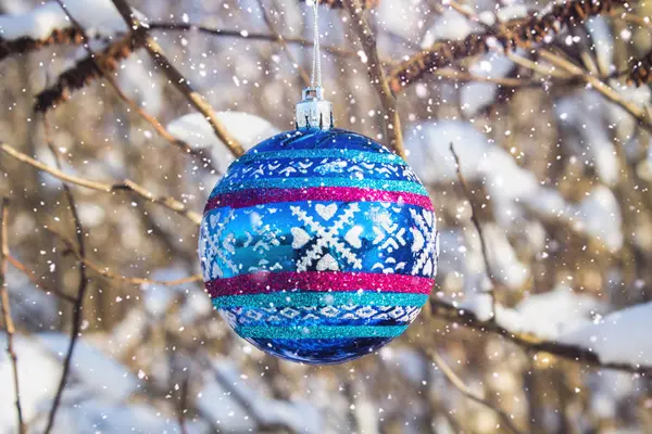 Una palla blu di Capodanno pende su un ramo con la neve. Giocattoli di Natale . — Foto Stock