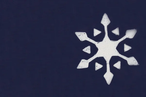 Jeden biały snowflake pomalowane farbą za pomocą wzornika na ciemnym niebieskim tle. Miejsce. — Zdjęcie stockowe
