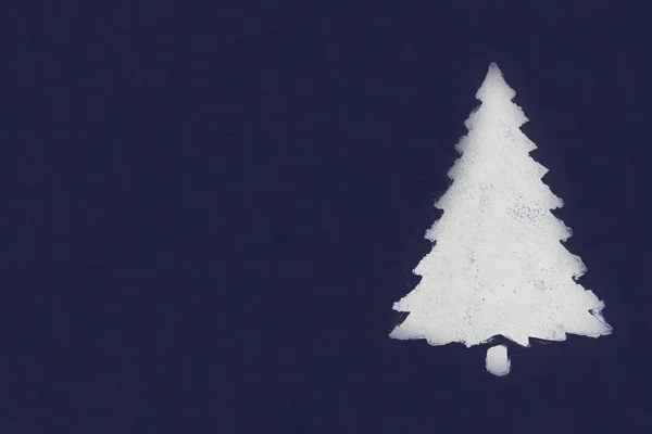 Одна белая елка, окрашенная краской через трафарет на темно-синем фоне. Копирование пространства . — стоковое фото