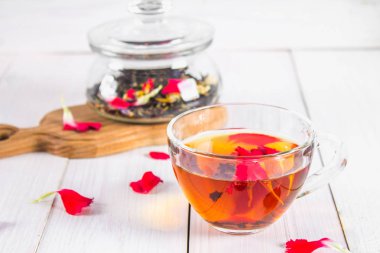 Bir bardak çay, bir banka bir siyah bitkisel fl ile arka planda