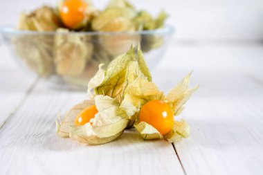 Egzotik meyveler physalis Beyaz ahşap bir masa üzerinde.
