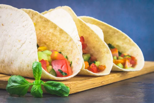 Traditionele Mexicaanse taco's met vlees en groenten op houten achtergrond. — Stockfoto