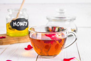 Çiçek siyah çay, bal olabilir, bir beyaz tahta masada yaprakları.