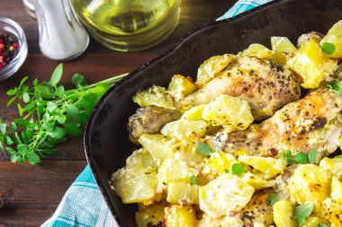 Kimyon ve sarımsak ile patates ile kavrulmuş tavuk budu.