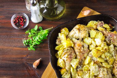 Kimyon ve sarımsak ile patates ile kavrulmuş tavuk budu.