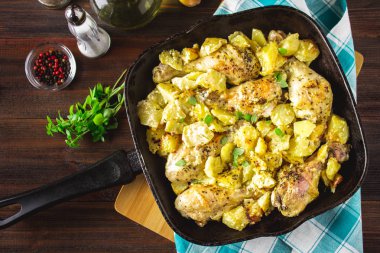 Kimyon ve sarımsak ile patates ile kavrulmuş tavuk budu.