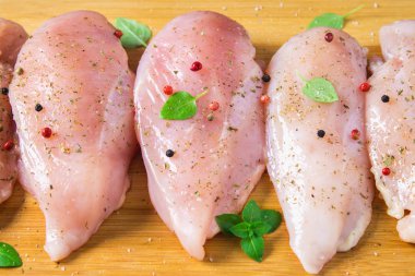 Çiğ tavuk fileto kesme tahtası ahşap bir masa arka planı. Et yemek pişirmek için malzemeler. Düz lei. Üstten Görünüm.