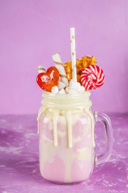 Pembe yüzlü, krem üzerinden Freakshake. Lolipop, waffle ve hatmi ile Monstershake. Bir Mason kavanoza aşırı milkshake. Mor pembe.