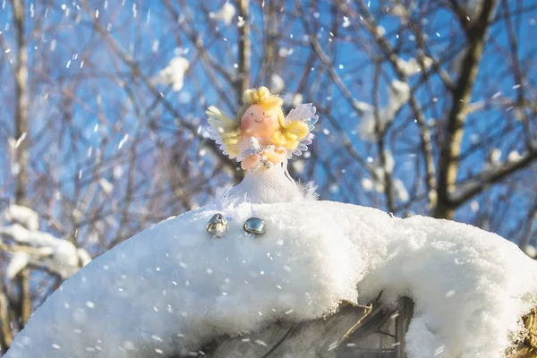На снегу сидит игрушка-ангел-фея. Рождественские игрушки . — стоковое фото