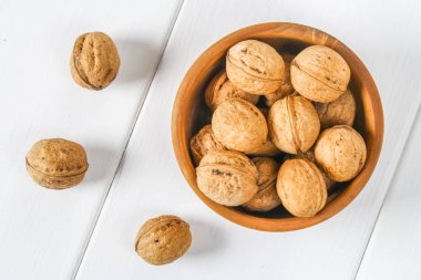 Beyaz ahşap bir masa üzerinde ceviz kabukları bir kemikten.
