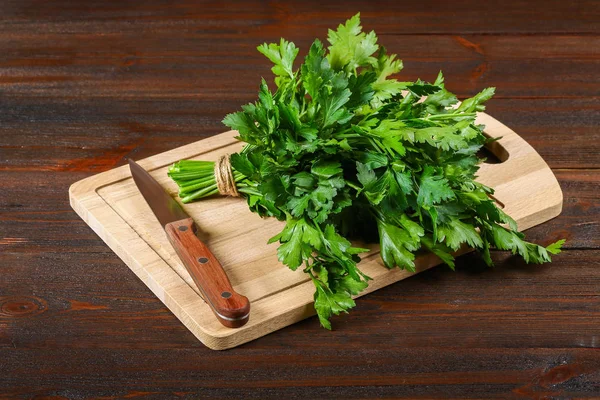 Um monte de salsa verde em uma mesa de madeira com uma faca . — Fotografia de Stock