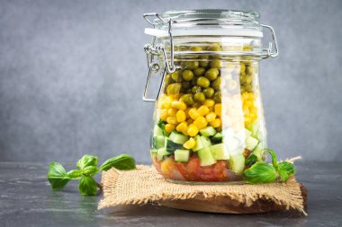 Sağlıklı ev yapımı salata sebze, salatalık, domates, bezelye ve Mısır - sağlıklı diyet, Detoks, saf gıda veya vejetaryen kavramı ile bir kavanoz içinde.