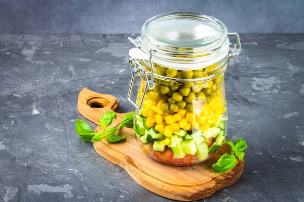 Healthy homemade salad in a jar with vegetables, cucumbers, tomatoes, peas and corn - Healthy diet, detox, pure food or vegetarian concept.