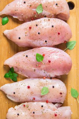 Çiğ tavuk fileto kesme tahtası ahşap bir masa arka planı. Et yemek pişirmek için malzemeler. Düz lei. Üstten Görünüm.