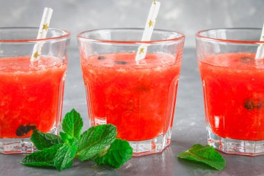 Karpuz smoothies gözlük ile nane yaprakları bir koyu gri beton özgeçmişlerine.