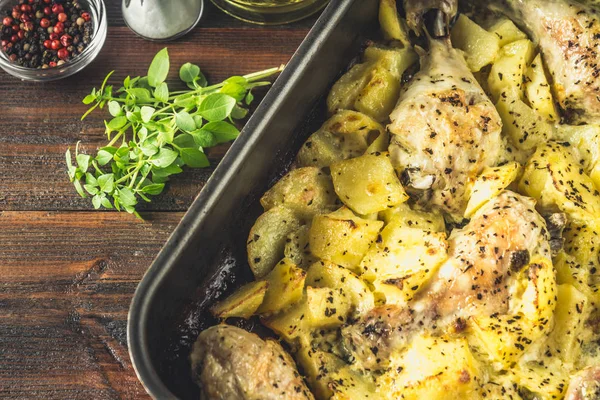 Kimyon ve sarımsak ile patates ile kavrulmuş tavuk budu.