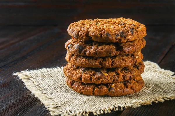 Ev yapımı yulaf ezmeli kurabiye. Çul kahverengi ahşap bir masa üzerinde bir yığın.