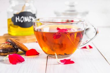 Bir fincan çay, bisküvi, konserve bal arka planda ve 