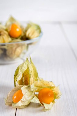 Egzotik meyveler physalis Beyaz ahşap bir masa üzerinde.