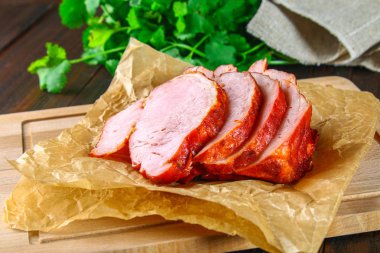 Salantro ile kahverengi ahşap bir masa üzerinde domuz Loin kızartma dilimlenmiş.