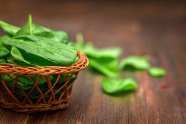 Taze sulu ıspanak ahşap bir kahverengi masa üzerinde bırakır. Doğal ürünler, Yeşiller, sağlıklı gıda, vitaminler.