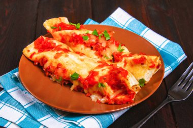 Ev yapımı tavuk enchiladas tabak ahşap masa üzerinde. Üstten Görünüm.