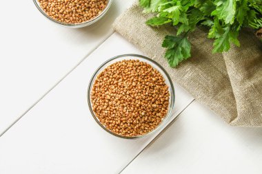 Ahşap arka plan üzerinde çul üzerinde ham buğday cam kase. Sağlıklı bir diyet yemek.