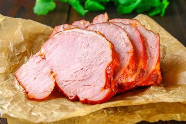 Salantro ile kahverengi ahşap bir masa üzerinde domuz Loin kızartma dilimlenmiş.