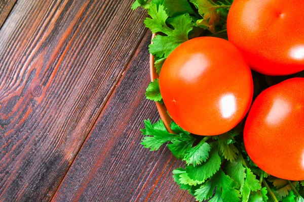 Świeże, czerwone pomidory z czosnkiem na drewnianym stole. — Zdjęcie stockowe
