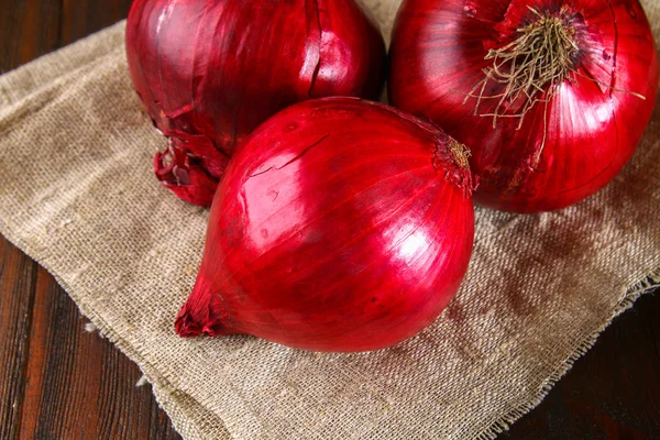 Φρέσκα κόκκινα κρεμμύδια σε ξύλινα φόντο. — Φωτογραφία Αρχείου