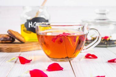 Çiçek siyah çay, bal olabilir, bir beyaz tahta masada yaprakları.