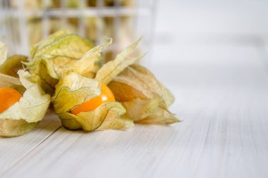Egzotik meyveler physalis Beyaz ahşap bir masa üzerinde.