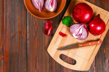 Taze kırmızı soğan ve doğranmış dilimleri ahşap bir masa. Üstten Görünüm.