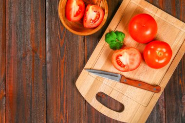 Taze kırmızı domates ve ahşap bir masa üzerinde Salantro ile dilimlenmiş yarıya indirir. Üstten Görünüm.