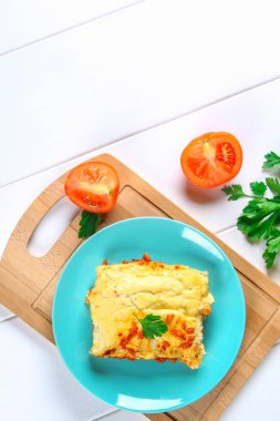 Geleneksel İtalyan makarna makarna. Pişmiş tüpler ile kıyma Beyaz ahşap bir masa üzerine Beşamel sos ve parmesan peyniri ile doldurulmuş.