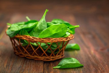 Taze sulu ıspanak ahşap bir kahverengi masa üzerinde bırakır. Doğal ürünler, Yeşiller, sağlıklı gıda, vitaminler.