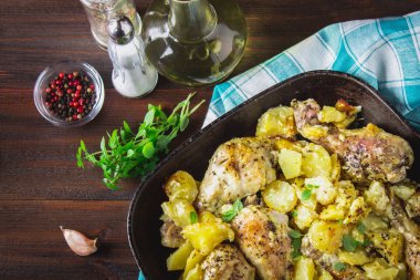 Kimyon ve sarımsak ile patates ile kavrulmuş tavuk budu.