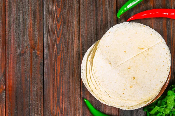 Tortillas de trigo integral sobre tabla de madera y verduras . —  Fotos de Stock