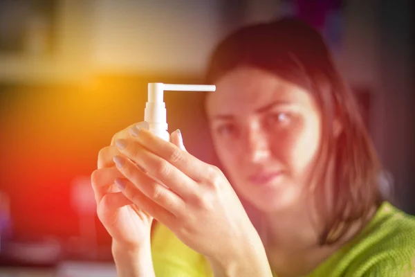 A rapariga está a considerar um spray para o nariz. Tratamento de constipações, gripe . — Fotografia de Stock