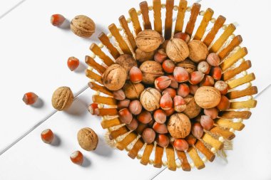 Beyaz ahşap bir masa üzerinde ceviz kabukları bir kemikten.