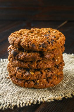 Ev yapımı yulaf ezmeli kurabiye. Çul kahverengi ahşap bir masa üzerinde bir yığın.