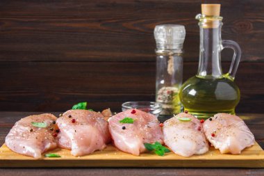 Çiğ tavuk fileto kesme tahtası ahşap bir masa arka planı. Yemek pişirmek için et malzemeler.