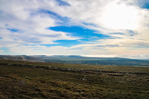 Grass in vorst na de vorst tegen de blauwe hemel, de velden en de bergen. — Stockfoto