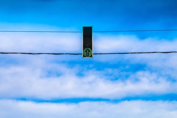 Três semáforos verdes pairam sobre a estrada contra o céu azul. Permitir sinal . — Fotografia de Stock