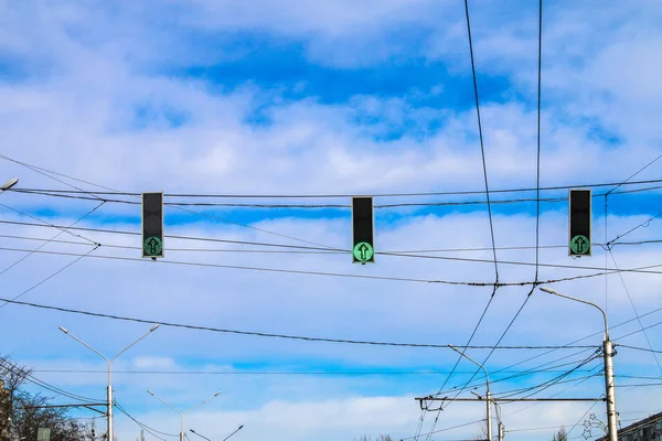 Três semáforos verdes pairam sobre a estrada contra o céu azul. Permitir sinal . — Fotografia de Stock